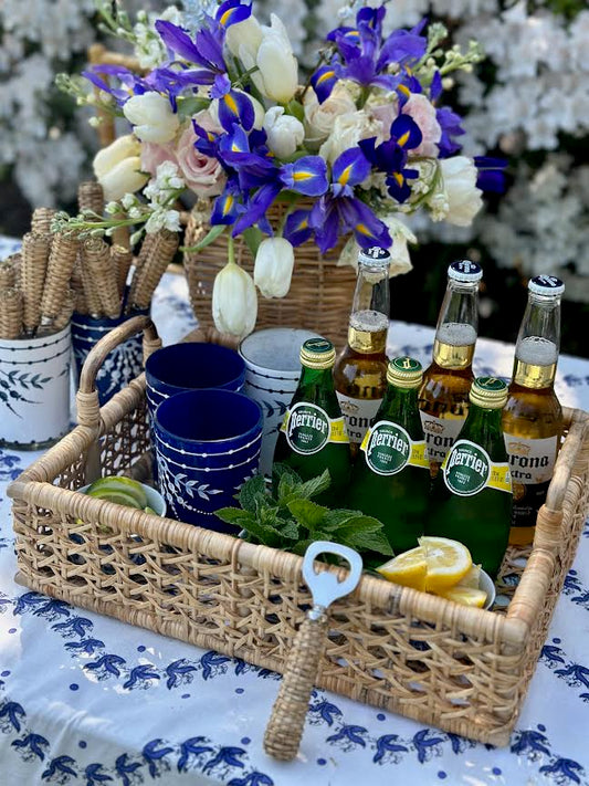 a basket with bottles and cups on a table
