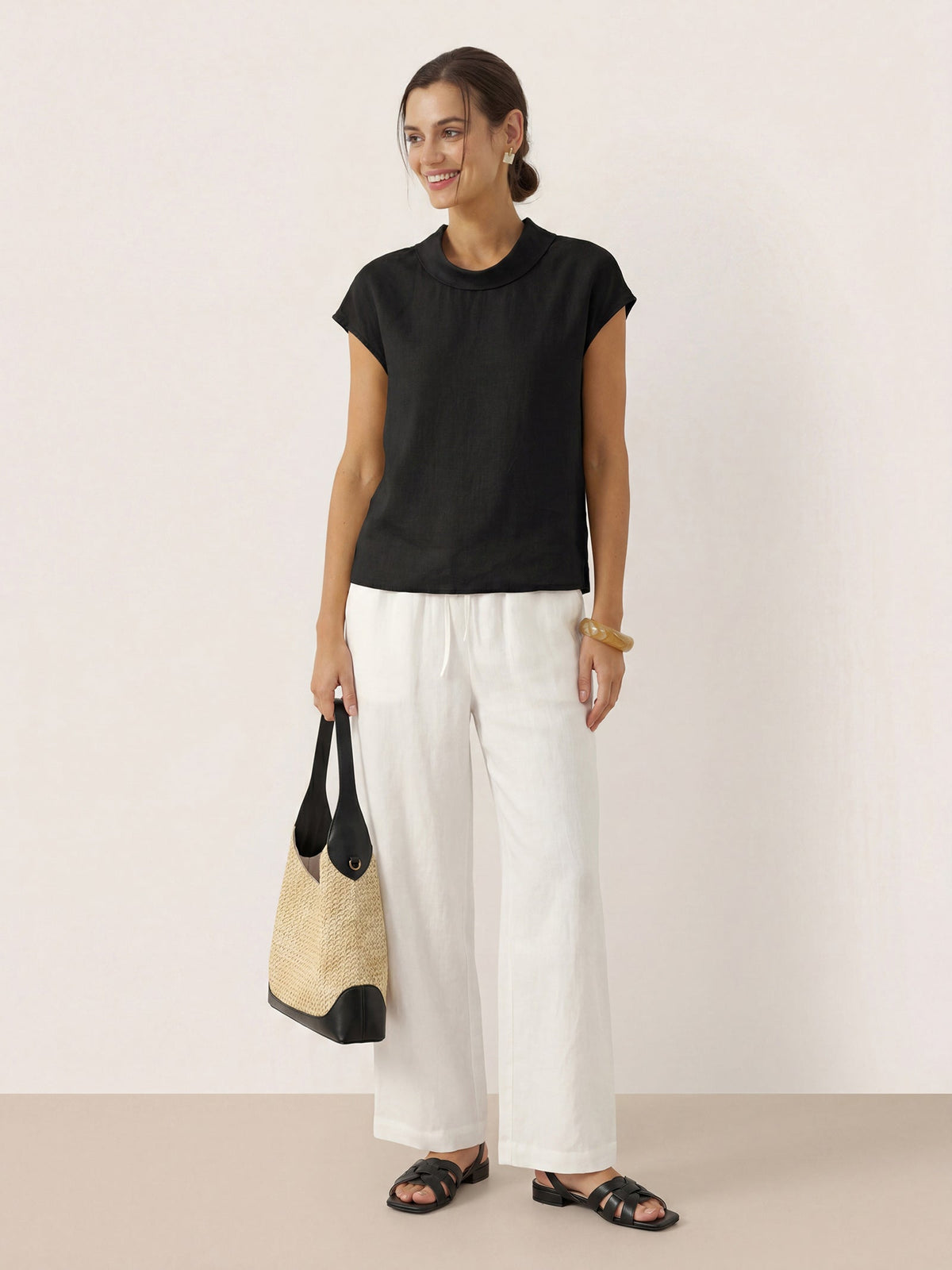 a woman in white pants and black shirt