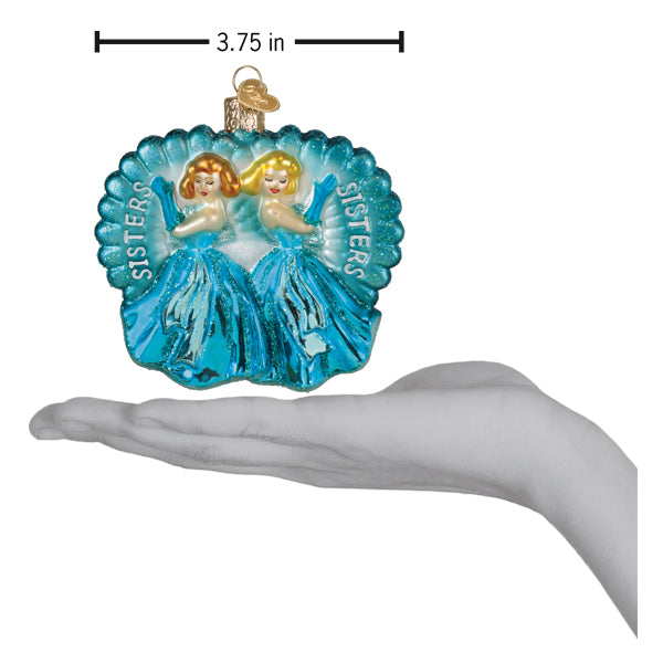 a hand holding a blue and gold ornament