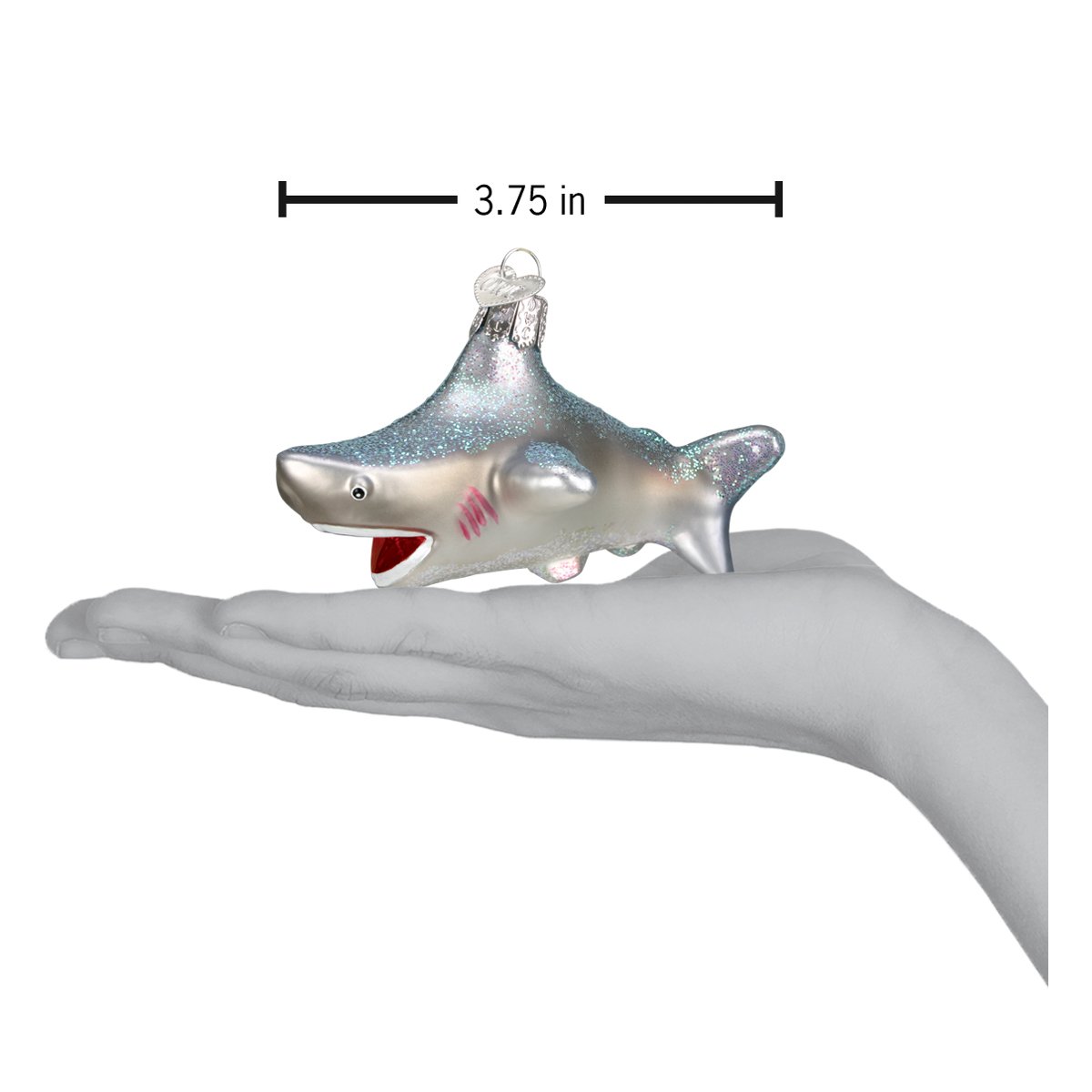a hand holding a shark ornament