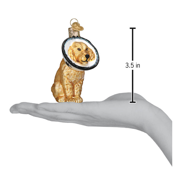 a hand holding a gold dog ornament