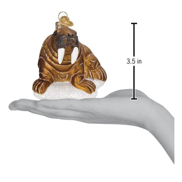 a hand holding a gold walrus ornament