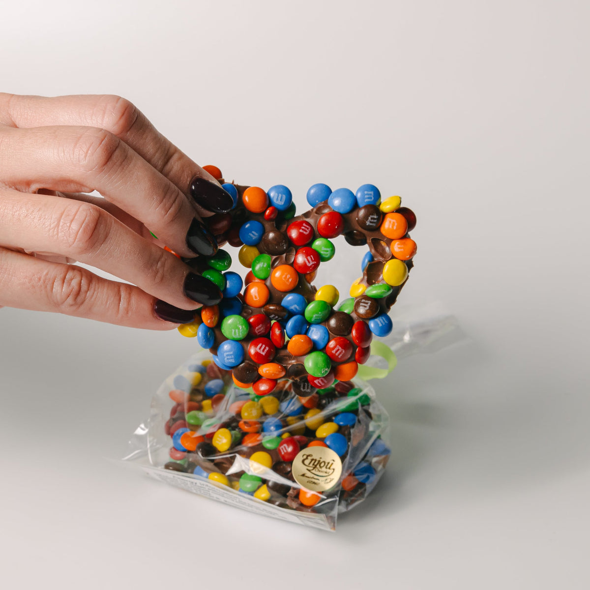 a hand holding a heart shaped candy