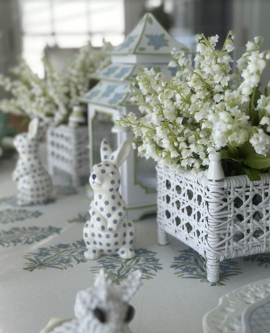 a white and blue bunny figurines and white flowers on a table