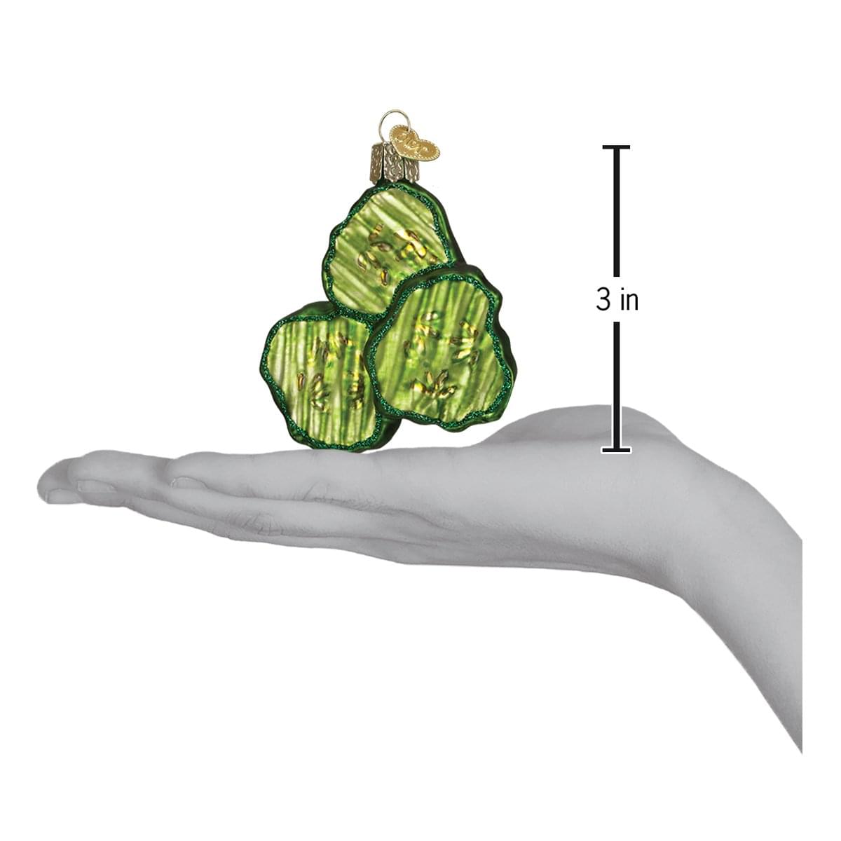 a hand holding a green ornament