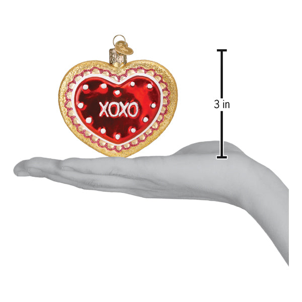 a hand holding a heart shaped ornament