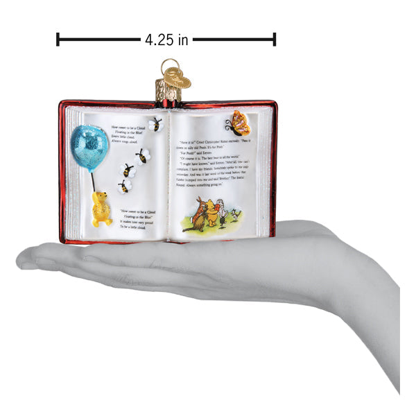 a hand holding a book shaped ornament