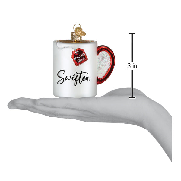 a hand holding a small white mug