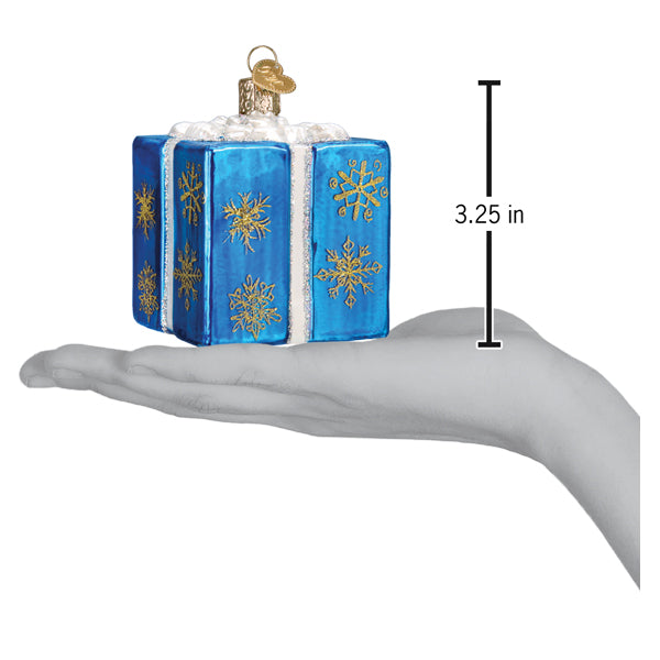 a hand holding a blue box with gold snowflakes