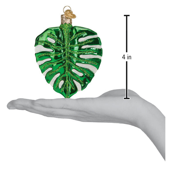 a hand holding a green and white ornament