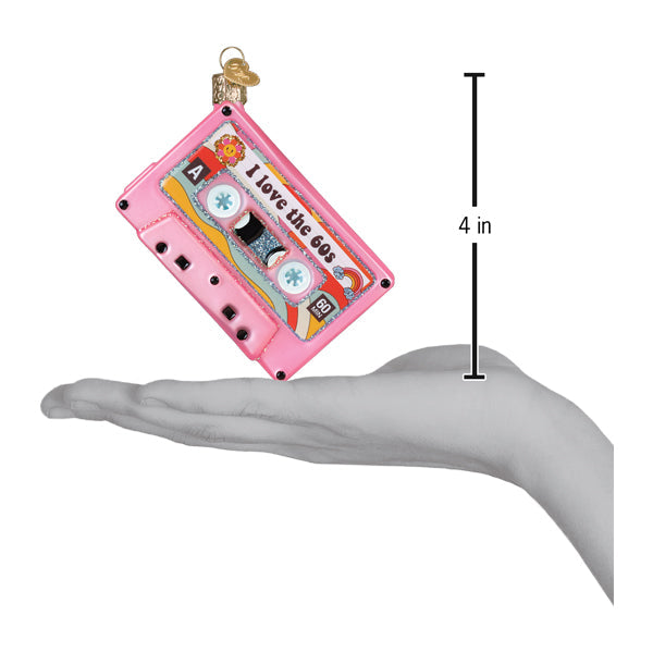 a hand holding a pink cassette tape ornament