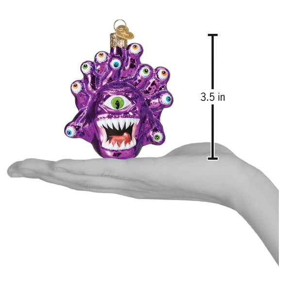 a hand holding a purple monster ornament