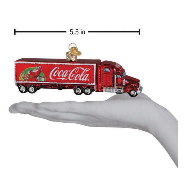 a hand holding a red truck ornament