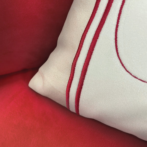 a white pillow with red stitching