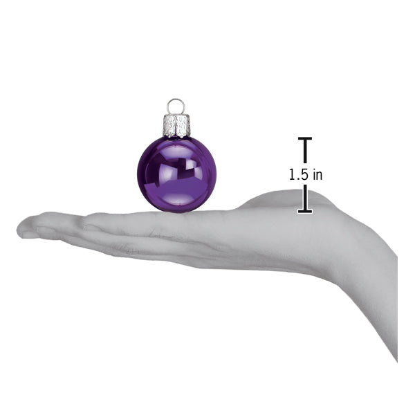 a hand holding a purple ornament