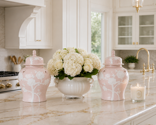 a vase of flowers and a candle on a marble counter