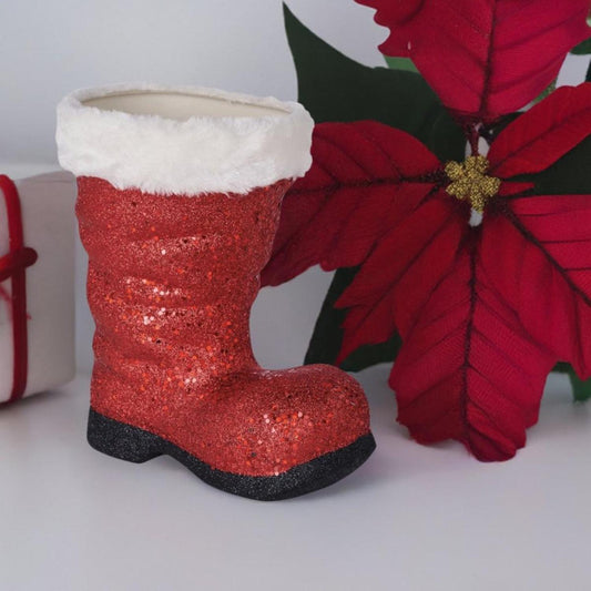 a red boot with white fur and a white box next to a white box with a red flower