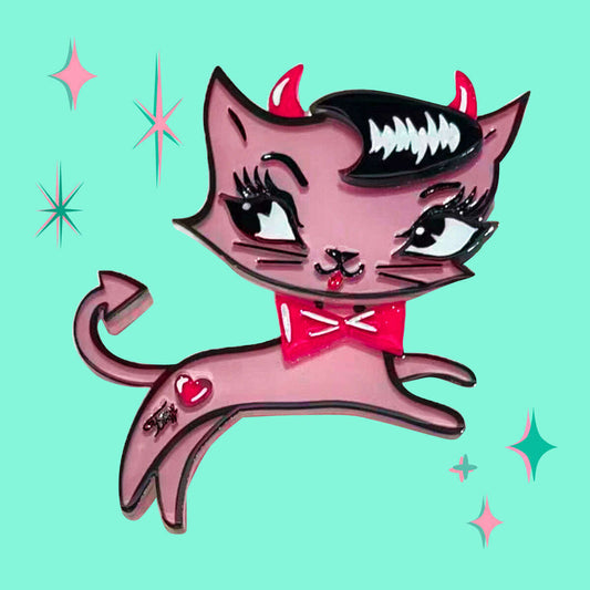 a pink cat pin with horns and red bowtie
