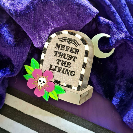 a tombstone with a flower and a crescent moon on a purple blanket