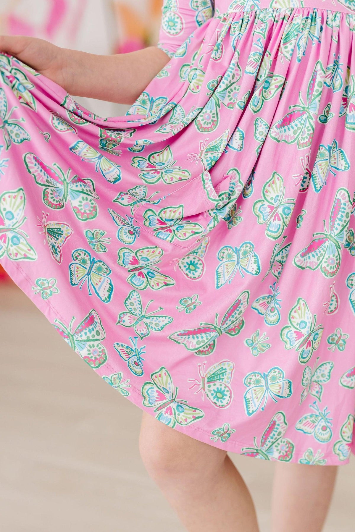 a woman wearing a pink dress with butterflies on it