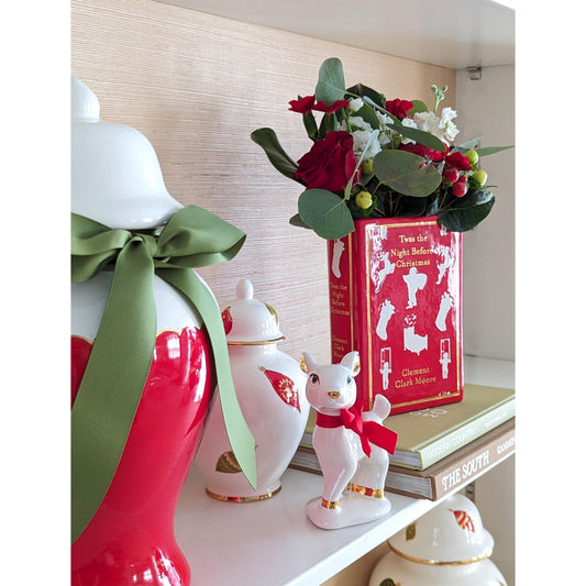 a white shelf with red and white vases and flowers