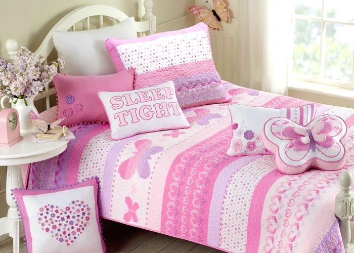 a bed with pink and white pillows