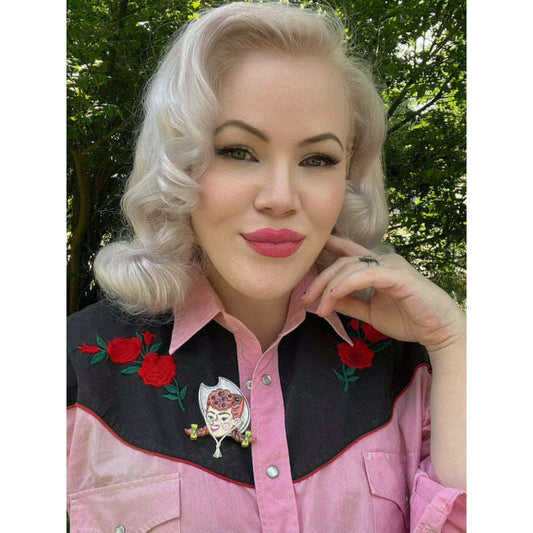 a woman with blonde hair wearing pink shirt with flowers on it
