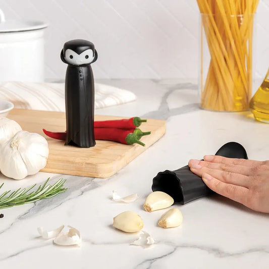a person's hand peeling garlic