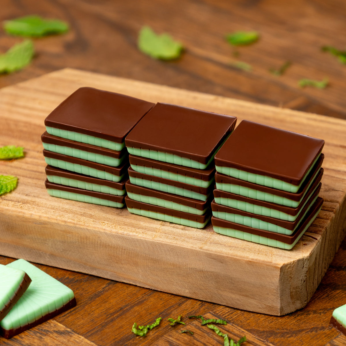 a stack of chocolate squares on a wood board