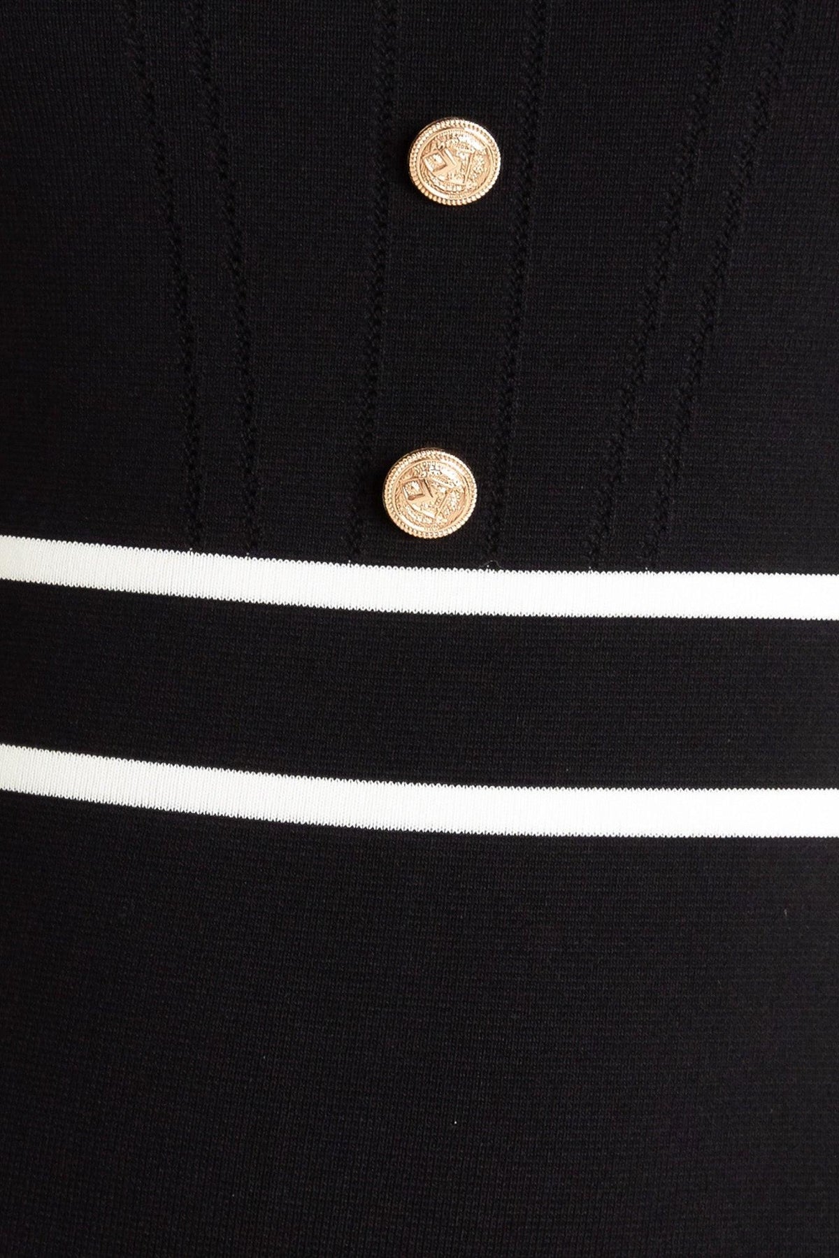 a close up of a button on a black and white striped shirt