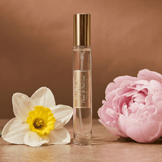 a bottle of perfume next to a flower