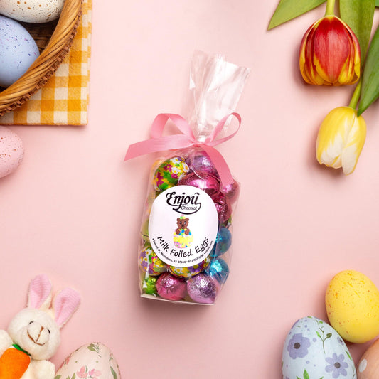 a bag of candy next to a basket of eggs and tulips