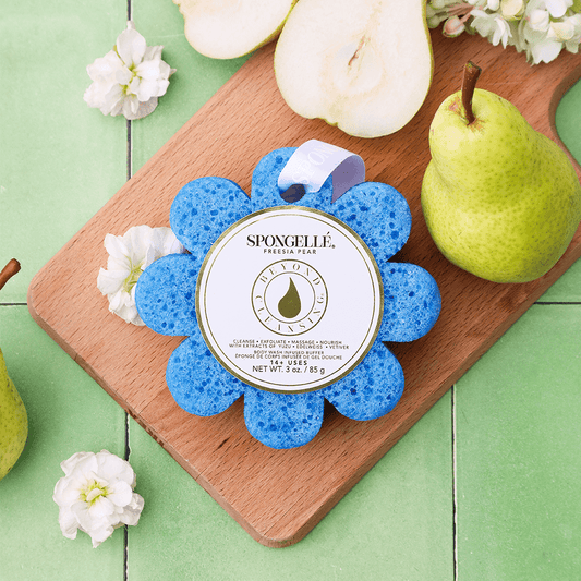 a blue sponge on a wooden board next to pears
