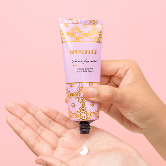a hand holding a tube of cream