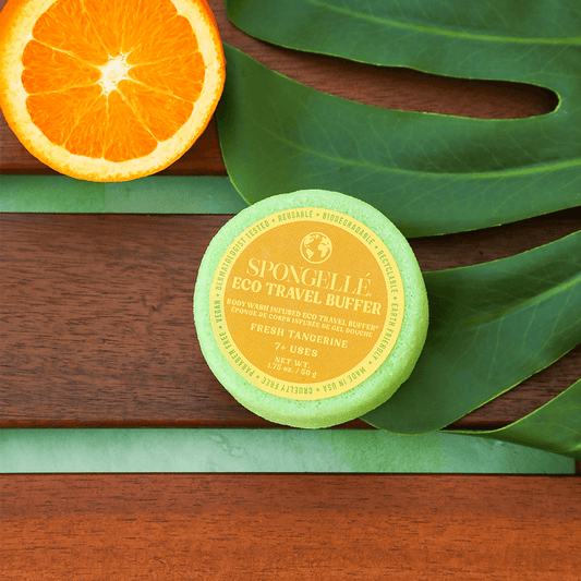 a round container with a yellow label next to an orange slice