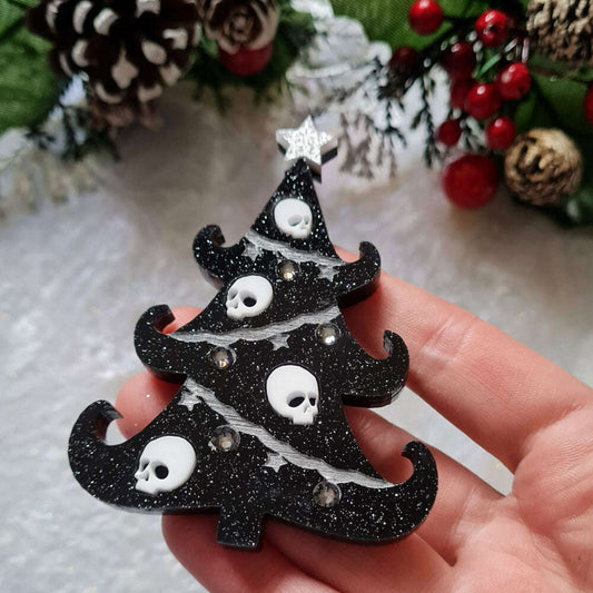 a hand holding a black christmas tree
