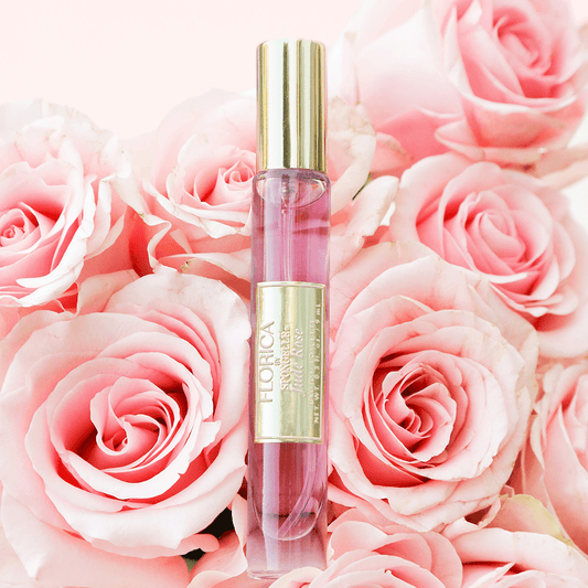 a bottle of perfume on a bouquet of pink roses