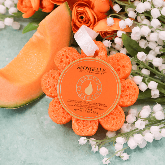 a orange sponge next to flowers and a slice of melon