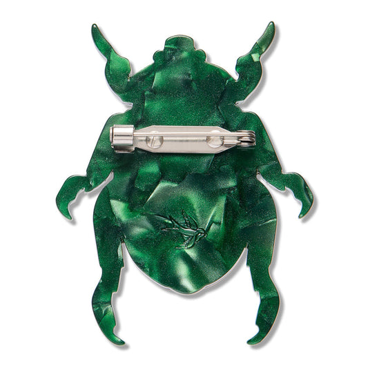 a green bug brooch with a silver pin