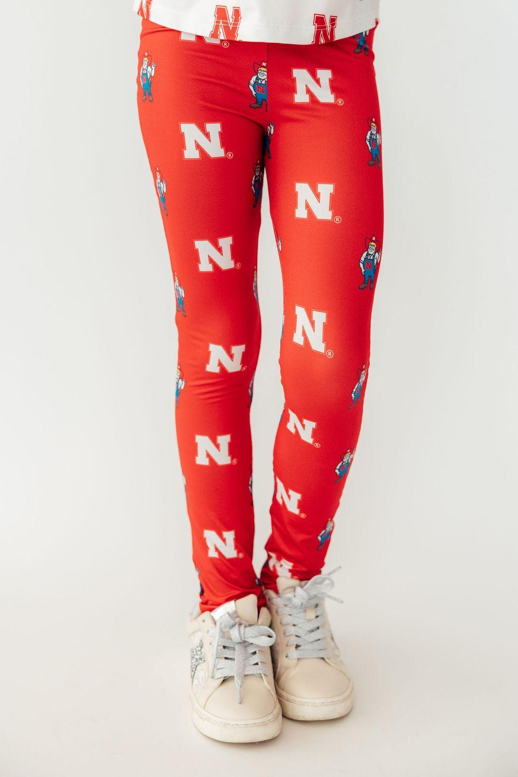 a person wearing red leggings with white shoes