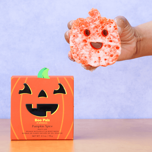 a hand holding a sponge with a face on it