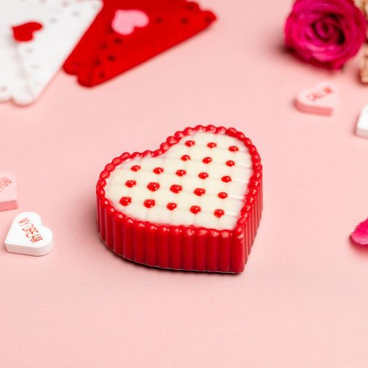 a heart shaped candy on a pink surface