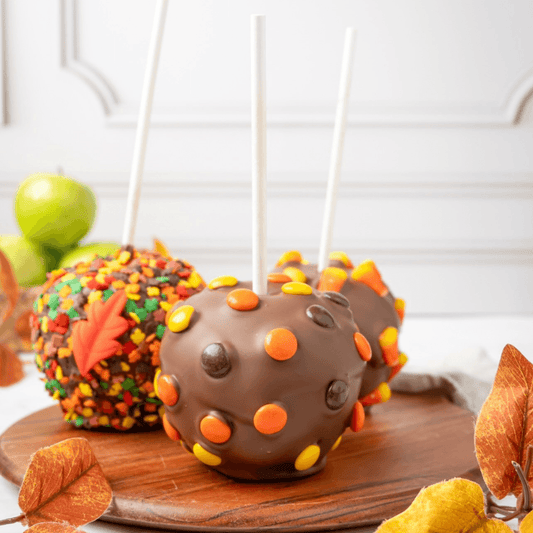 a group of candy apples on a wooden board