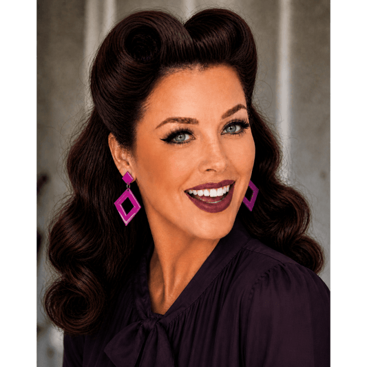 a woman with long hair and purple earrings