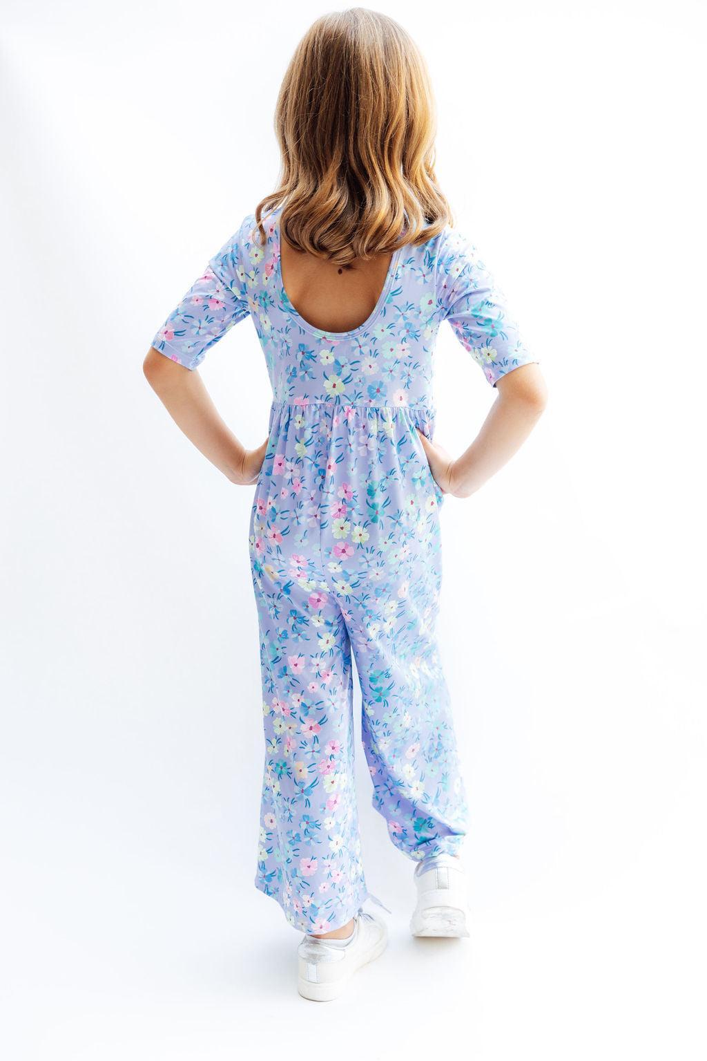 a woman in a blue jumpsuit with flowers on it