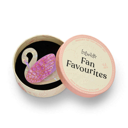 a pink swan shaped brooch in a round box