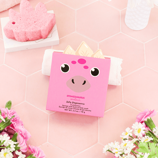 a pink box with a face and a sponge on a pink hexagon surface