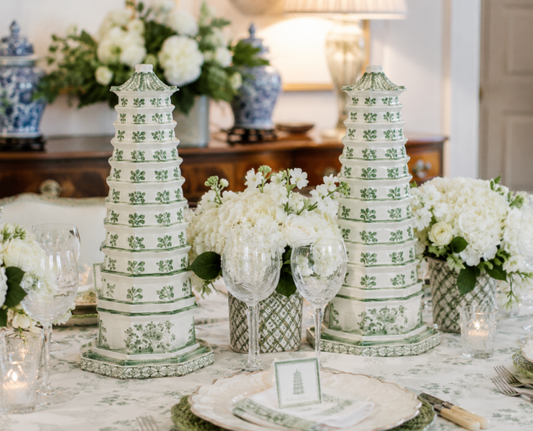 a table set with white flowers and vases