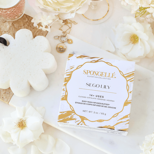 a box with a white and gold design on it next to flowers