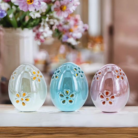 a group of ceramic eggs with flowers in the background